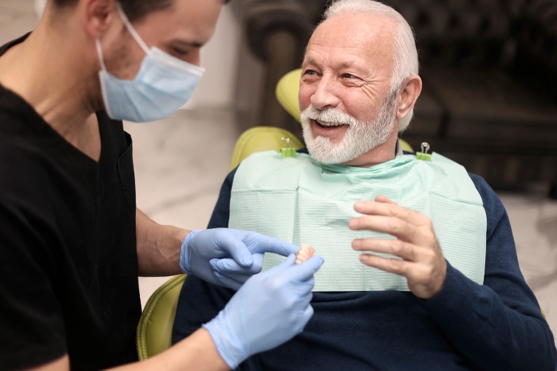 Man smiling after getting dental bridges for his front teeth in the Florence & Tri-State area.